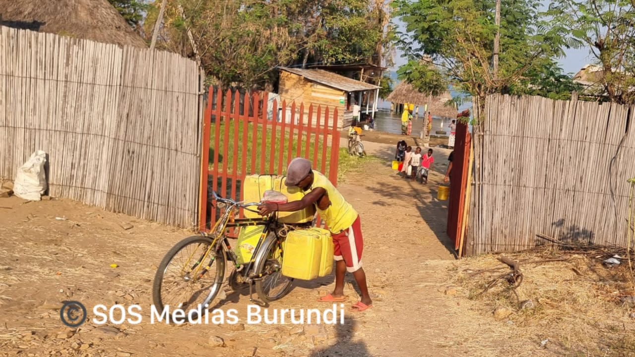 A bicycle taxi rider transports cans of drinking water for sale in the city of Rumonge, July 2024 (SOS Médias Burundi)
