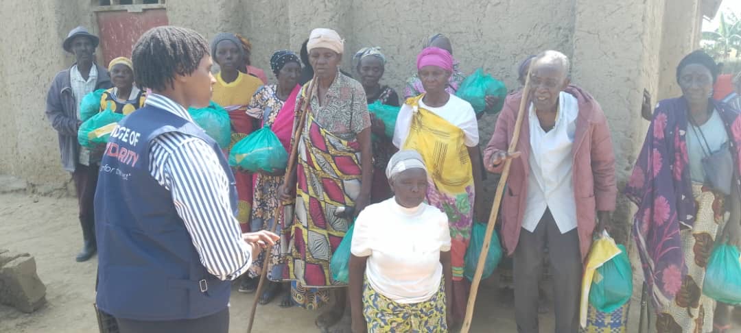 A Bridge of Solidarity agent in front of a group of vulnerable people after a clothing and shoe distribution session at the Nakivale camp, January 2025 (SOS Médias Burundi)
