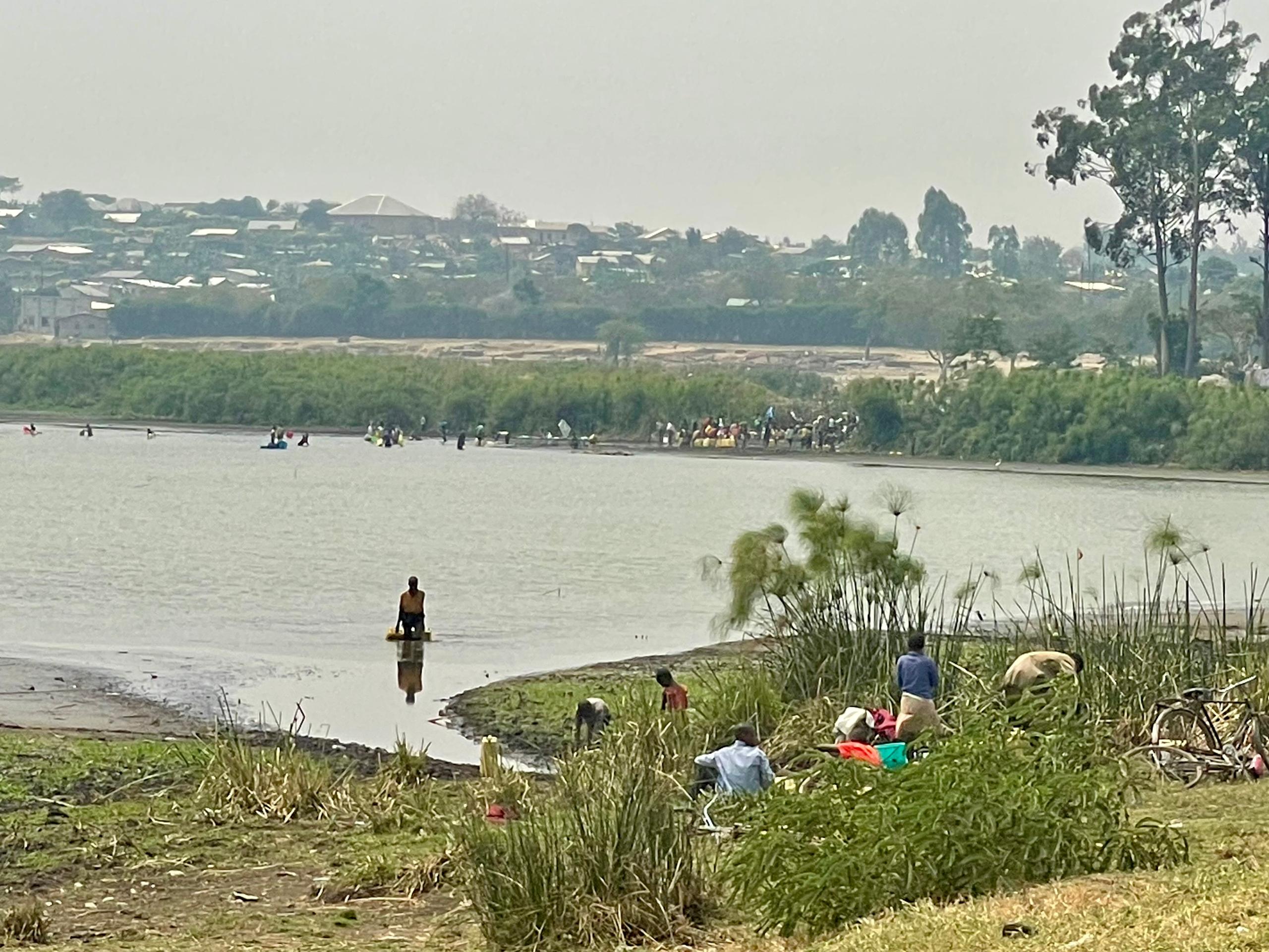 Des réfugiés puisent de l'eau dans un cours d'eau non loin du camp de Nakivale en Ouganda © SOS Médias Burundi