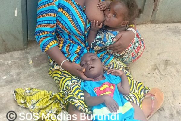 Emelyne Bukeyeneza mendie dans une rue de Bujumbura avec deux enfants, dont un en situation de handicap © SOS Médias Burundi