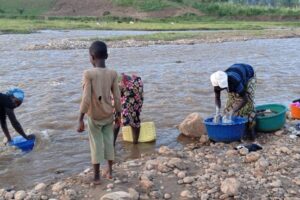 Des femmes lavent du linge et puisent de l’eau dans la rivière Nyamagana. Les habitants redoutent des maladies des mains sales, car cette eau est utilisée pour tous les besoins quotidiens © SOS Médias Burundi