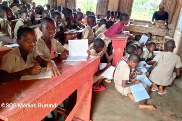 Une enseignante fait cours dans une salle de classe surchargée, où plusieurs élèves sont contraints de s’asseoir à même le sol, octobre 2024 © SOS Médias Burundi