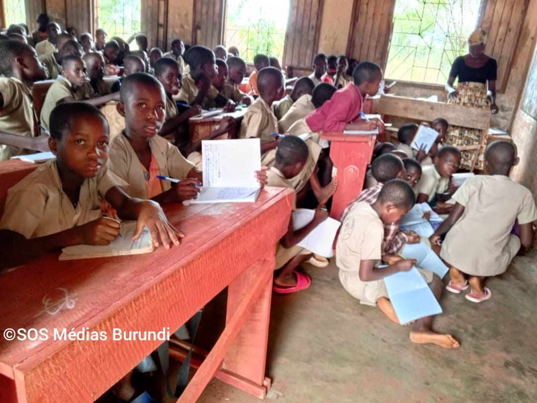Une enseignante fait cours dans une salle de classe surchargée, où plusieurs élèves sont contraints de s’asseoir à même le sol, octobre 2024 © SOS Médias Burundi